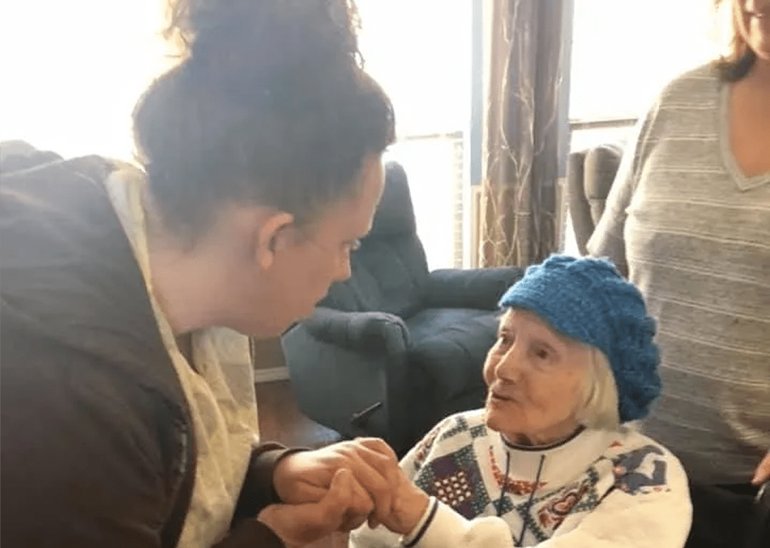 Woman holding elderly lady's hands