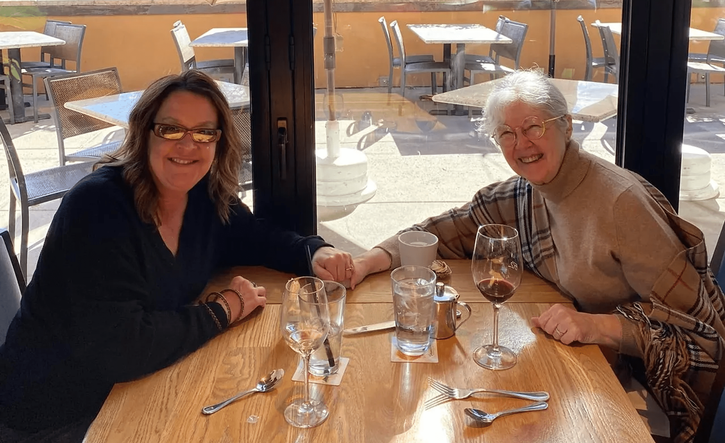 Smiling pair seated with wine glasses